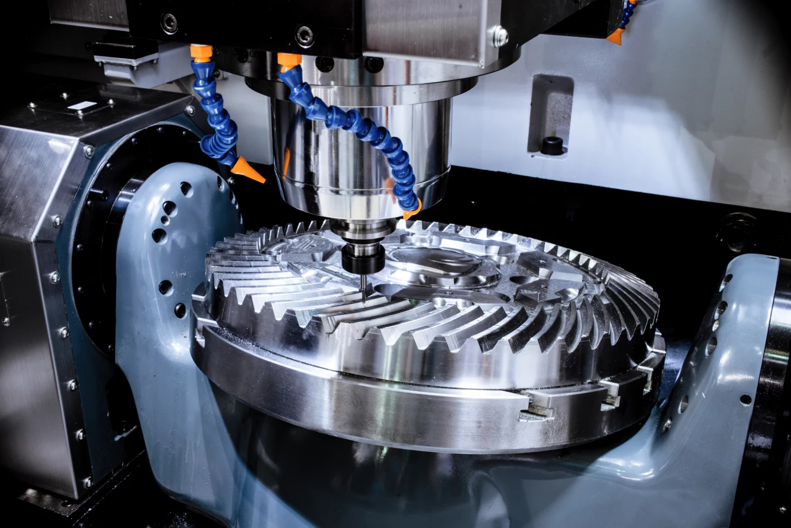 A modern CNC milling machine makes a large cogwheel.